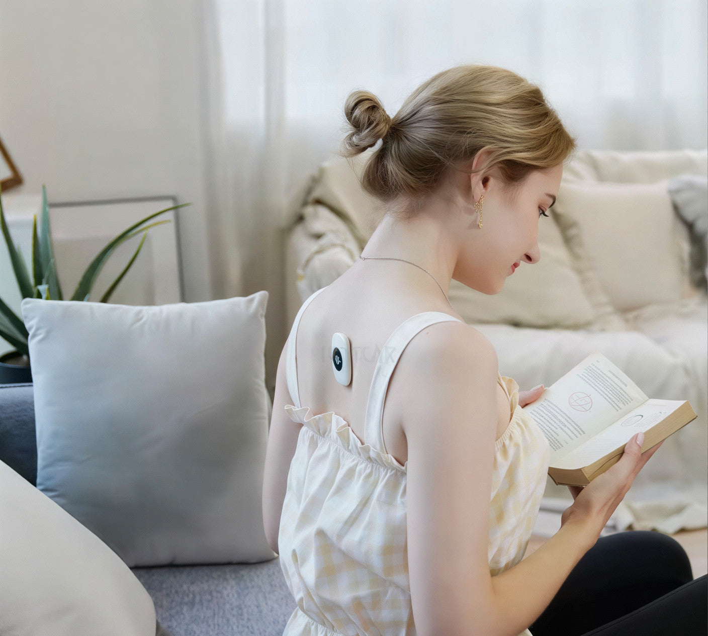 Woman wearing Sovela Smart Posture Trainer at home – discreet posture corrector worn while reading on couch