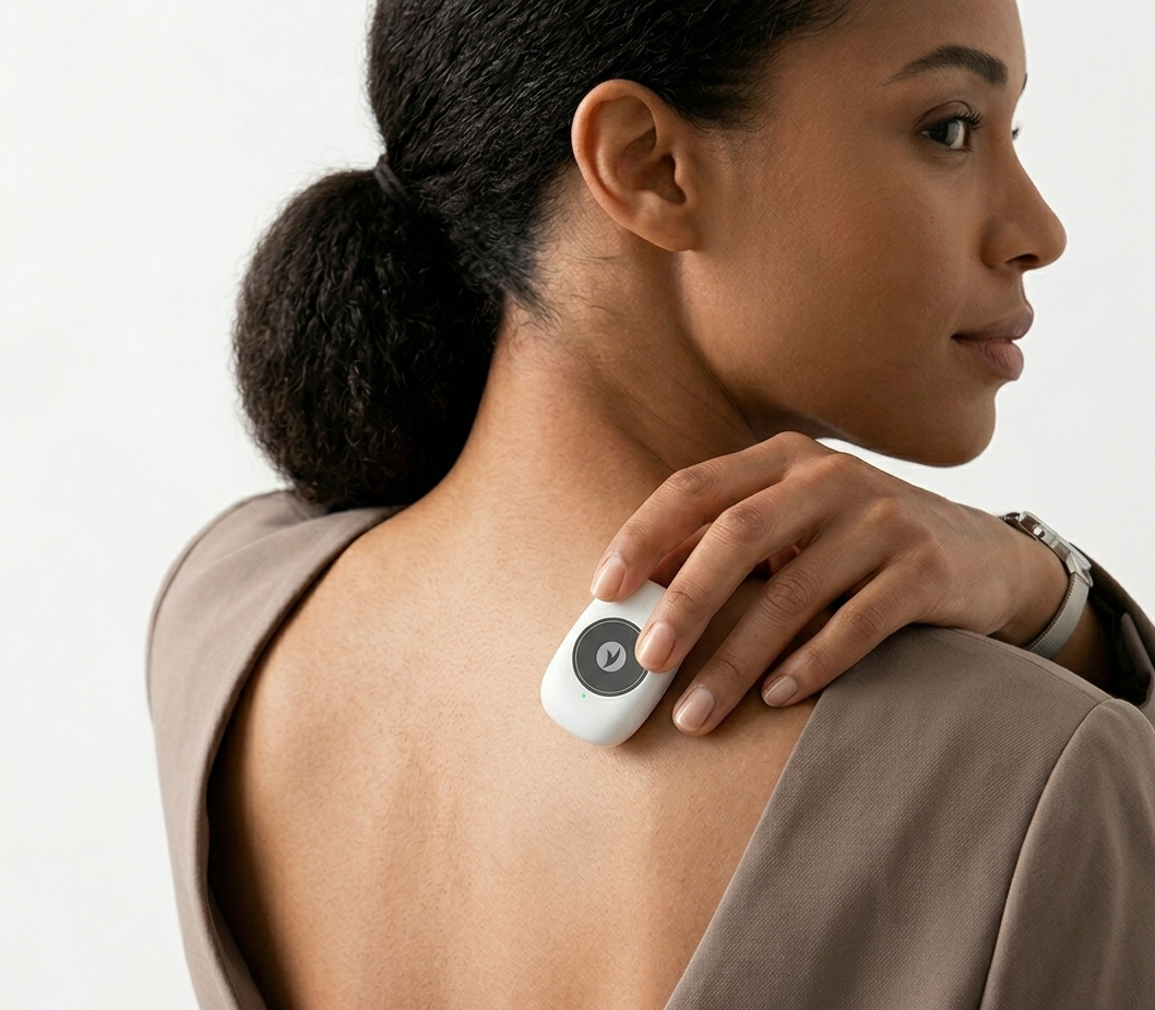 Woman wearing Sovela Smart Posture Trainer on shoulder – discreet wearable back posture corrector in everyday wear